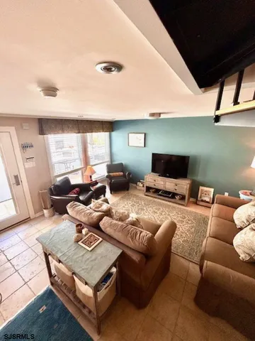 a living room with furniture wooden floor and a large window