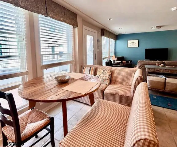 a living room with furniture a flat screen tv and a large window