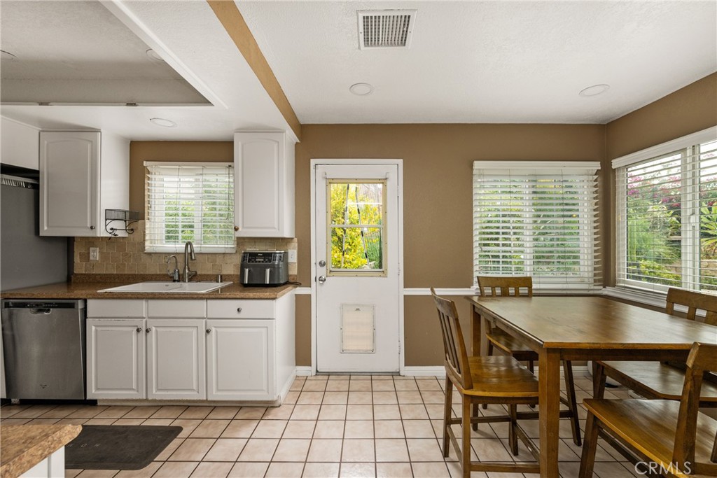 7233 Bel Air Street Corona, CA 92881 - Photo 25 of 39 a kitchen with a table chairs sink and cabinets