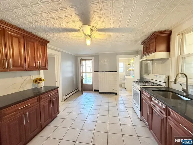 a kitchen with a sink a stove and cabinets