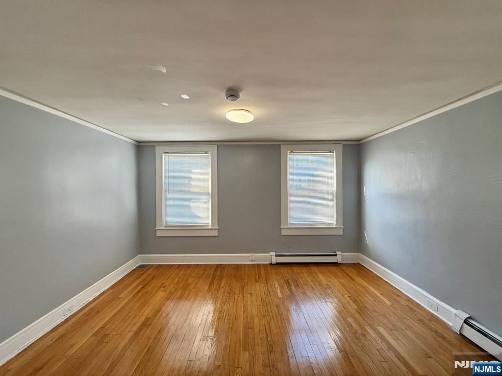 122 Cross Street, Unit 1 Harrison, NJ 07029 - Photo 4 of 10 an empty room with wooden floor and windows