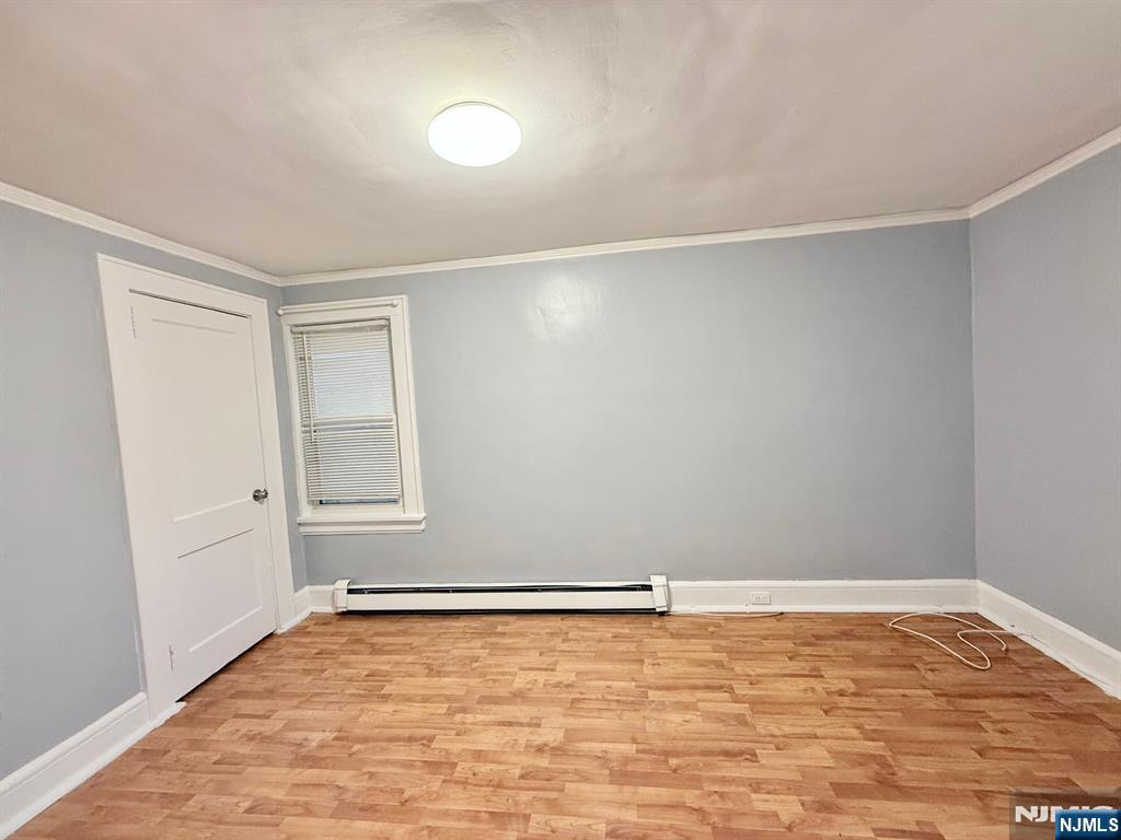 122 Cross Street, Unit 1 Harrison, NJ 07029 - Photo 6 of 10 an empty room with wooden floor and windows