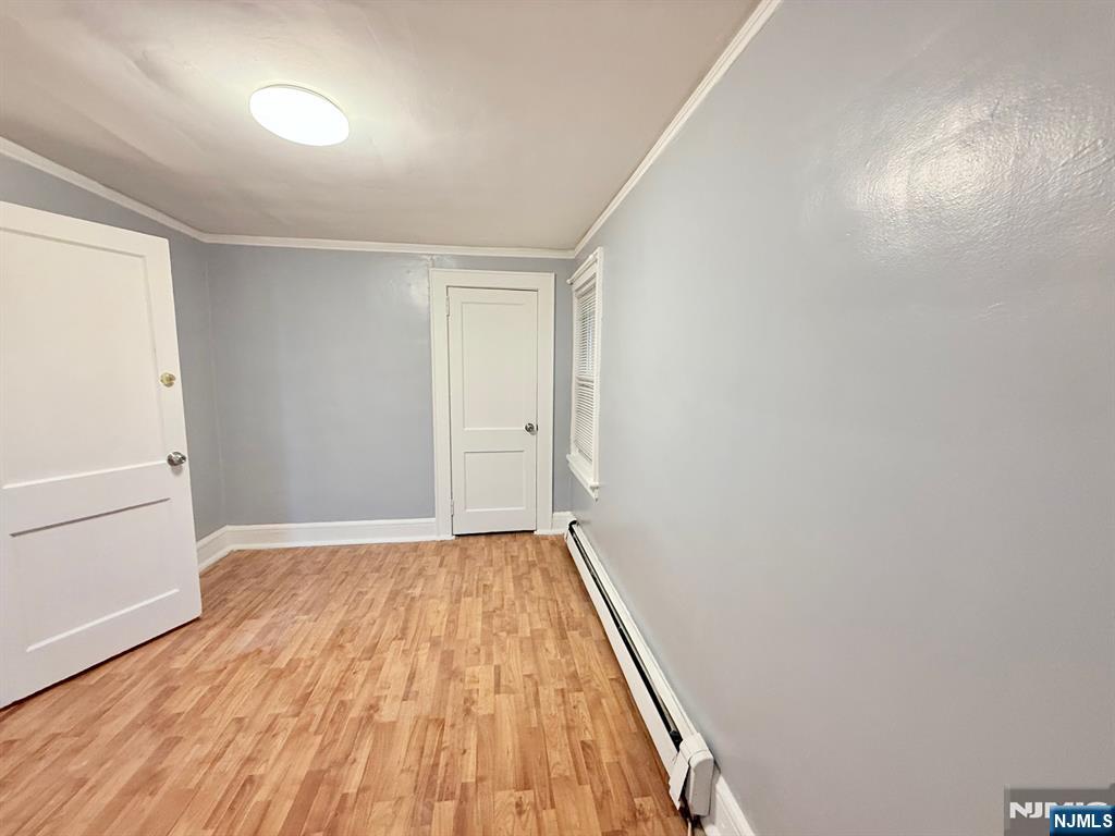 122 Cross Street, Unit 1 Harrison, NJ 07029 - Photo 7 of 10 an empty room with wooden floor and windows