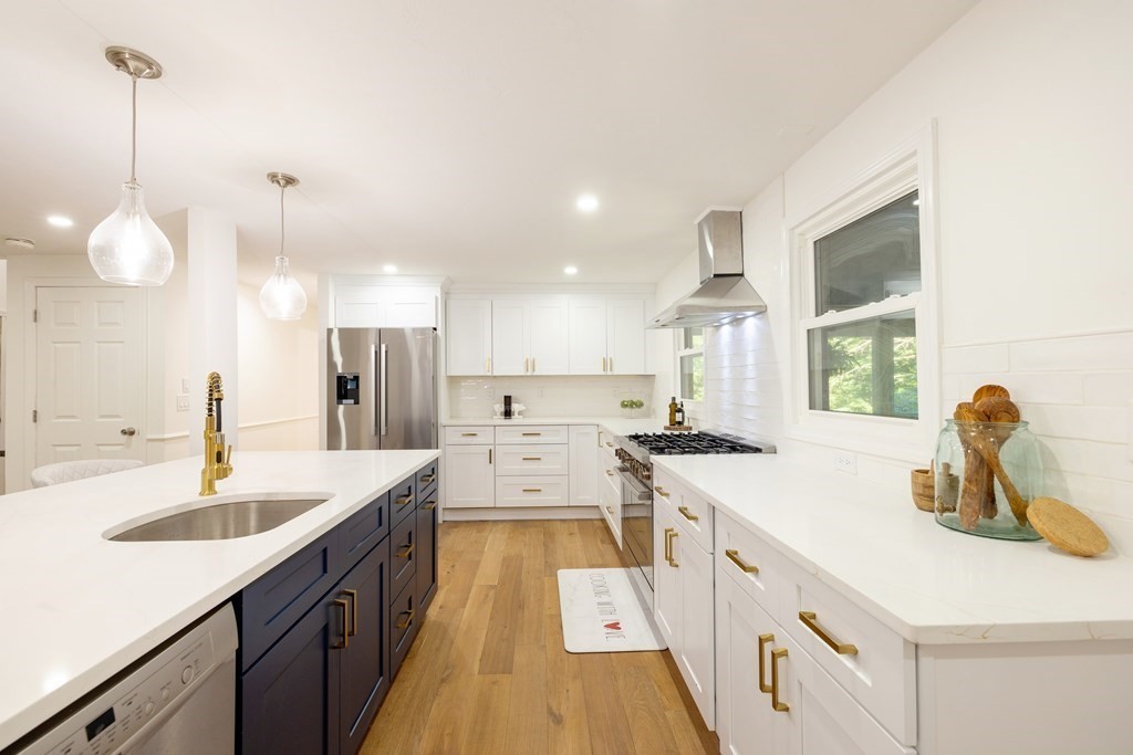 66 Patten Road Westford, MA 01886 - Photo 9 of 42 a large kitchen with kitchen island white cabinets and stainless steel appliances