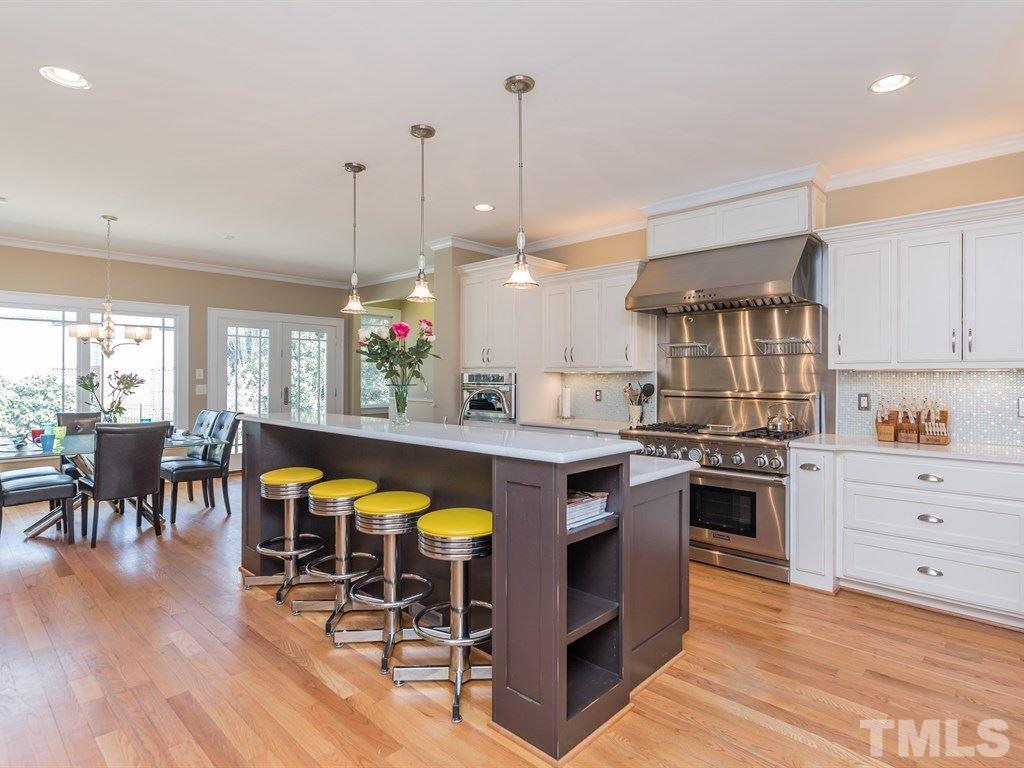 1910 Highland Place Raleigh, NC 27607 - Photo 6 of 25 a kitchen with stainless steel appliances granite countertop a stove a sink dishwasher a dining table and chairs with wooden floor