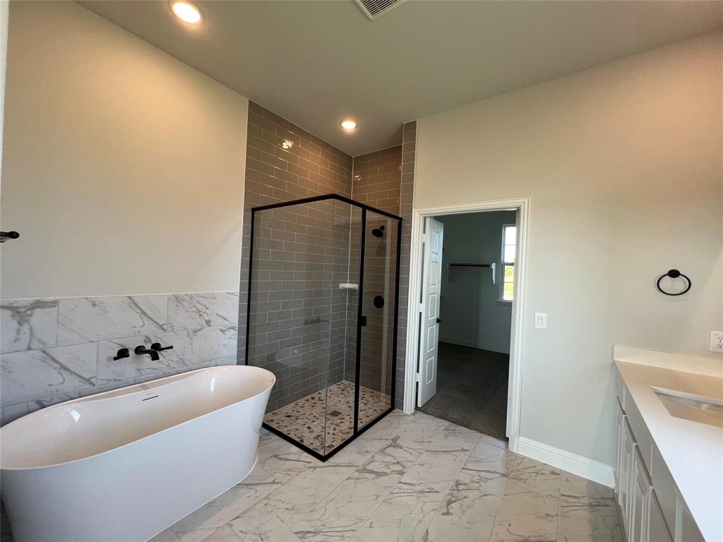 2108 Charters Circle Nevada, TX 75173 - Photo 19 of 37 Bathroom featuring vanity, a shower stall, a freestanding tub, light marble finish floors, and recessed lighting