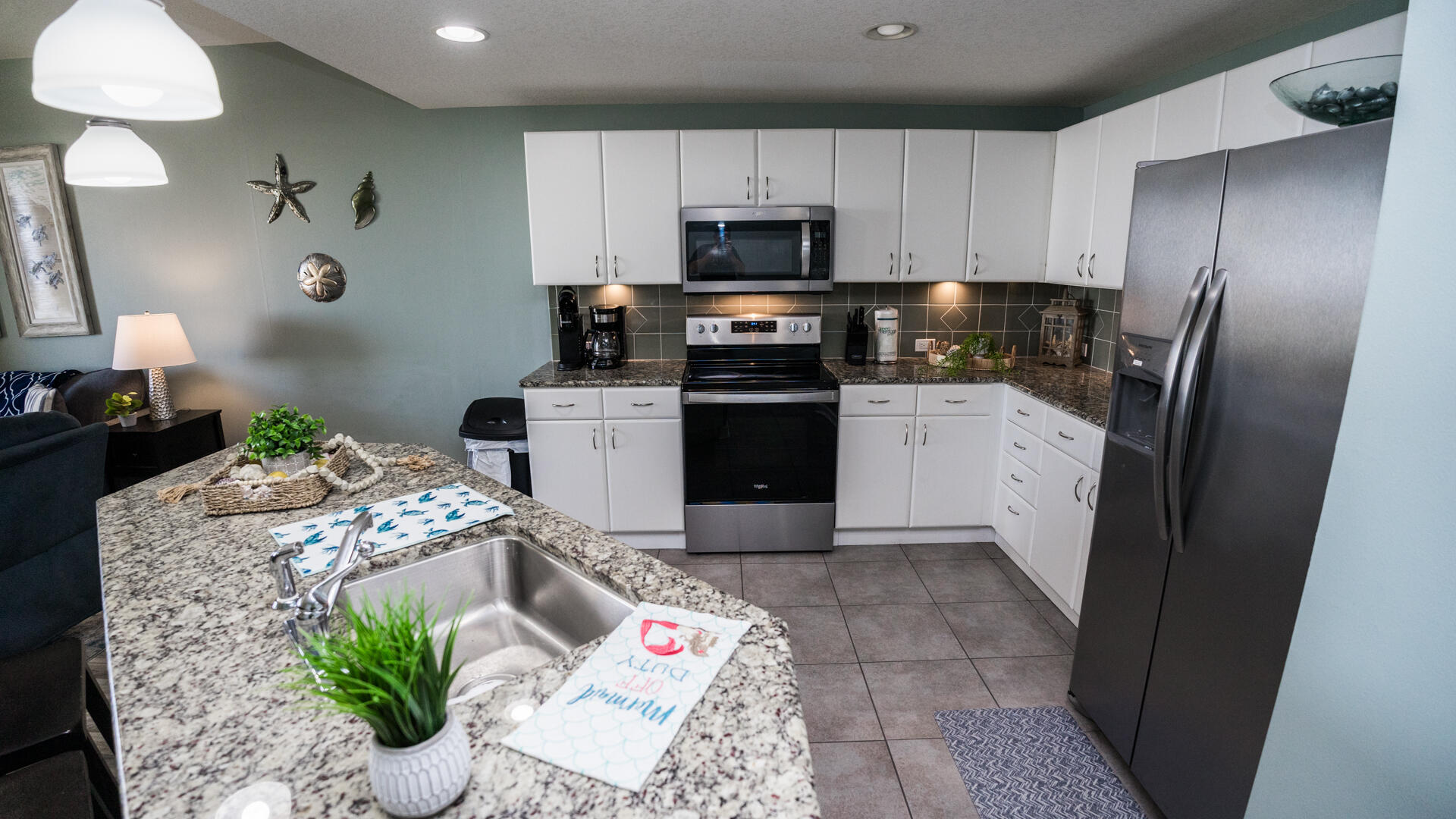 11800 Front Beach Road, Unit 703 Panama City Beach, FL 32407 - Photo 25 of 52 a kitchen with stainless steel appliances granite countertop a refrigerator sink and stove