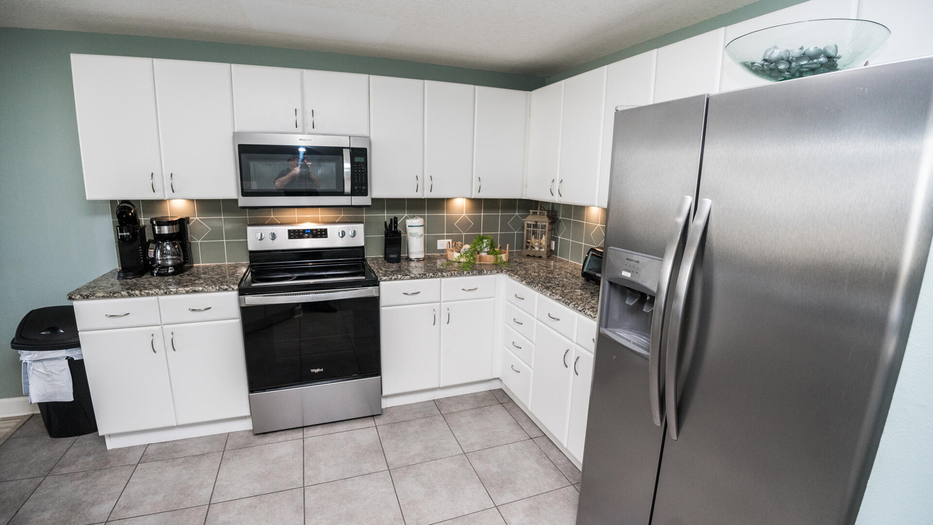 11800 Front Beach Road, Unit 703 Panama City Beach, FL 32407 - Photo 32 of 52 a kitchen with white cabinets stainless steel appliances and sink