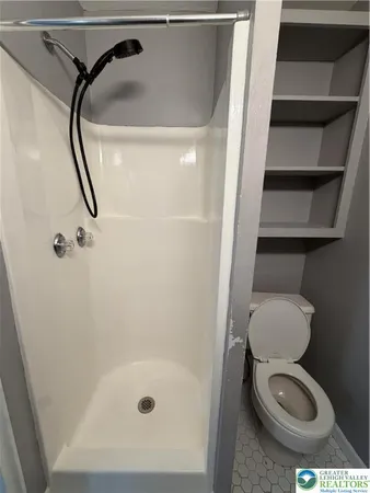 a bathroom with a toilet and a shower