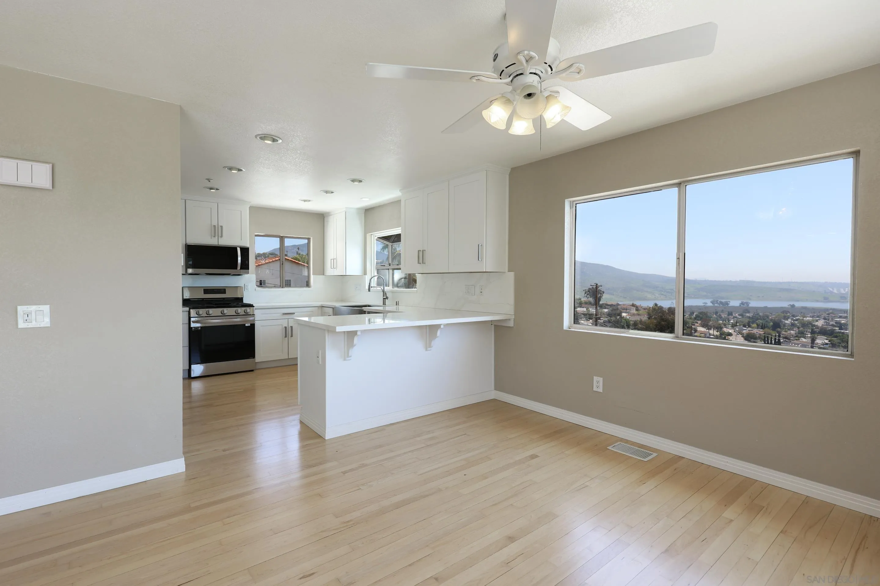 1412 San Miguel Avenue Spring Valley, CA 91977 - Photo 21 of 44 a kitchen with stainless steel appliances granite countertop a stove a sink and a refrigerator with wooden floors