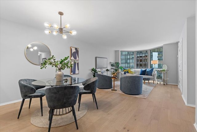 a living room with furniture a chandelier and a dining room