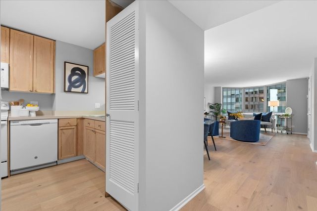 a kitchen with a refrigerator and white cabinets