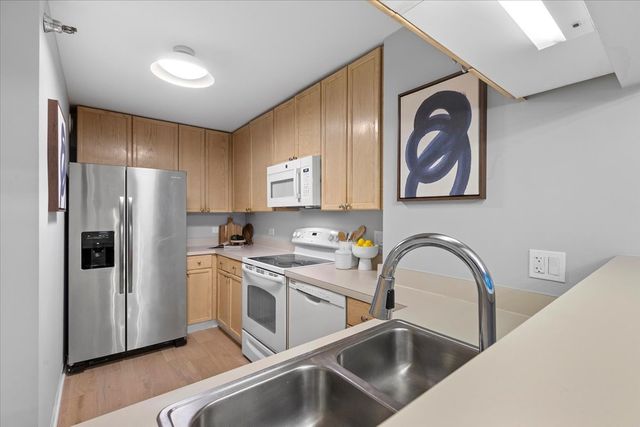 a kitchen with stainless steel appliances granite countertop a refrigerator and a sink