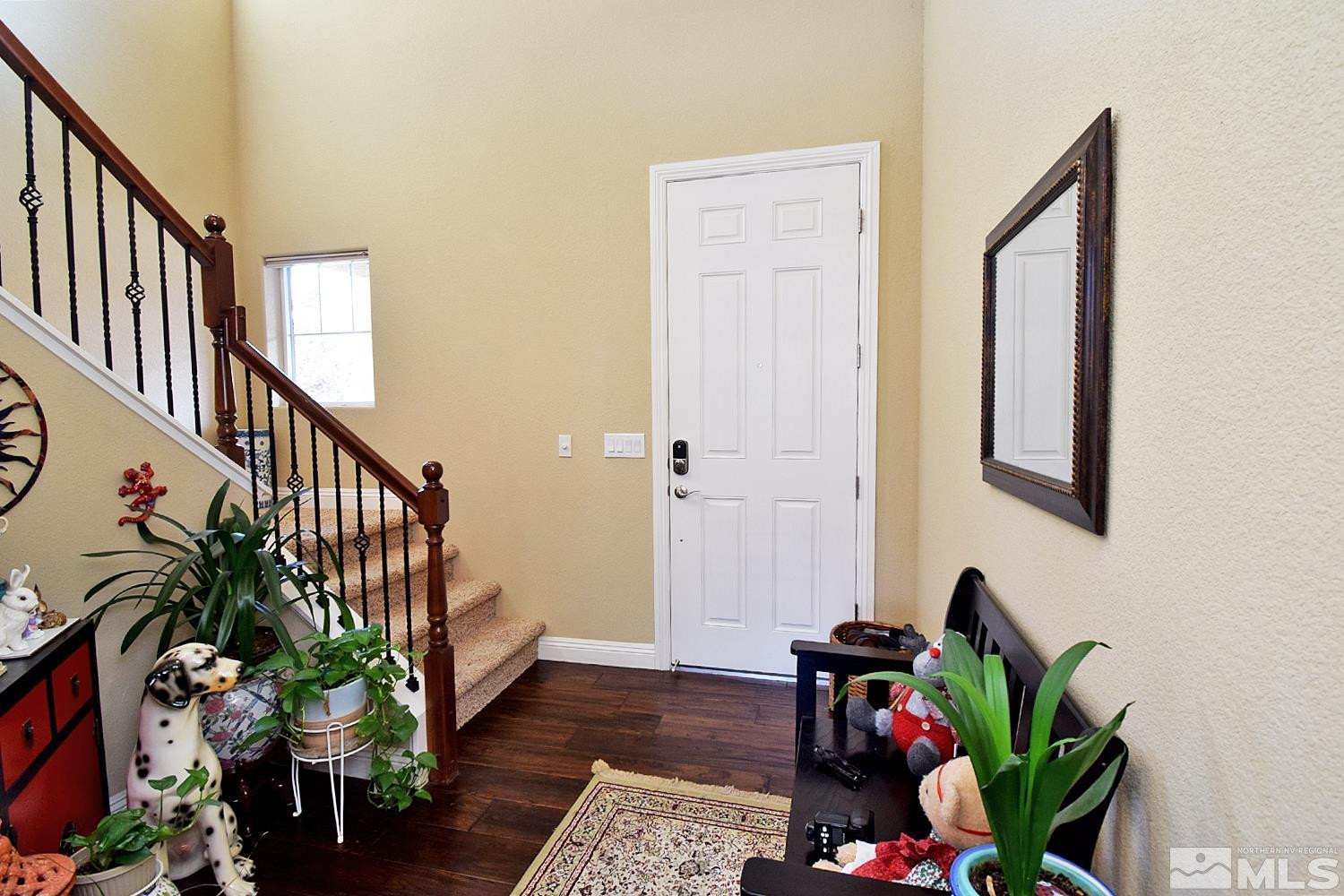10685 Solano Court Reno, NV 89521 - Photo 18 of 32 a hallway with wooden floor stairs and a potted plant