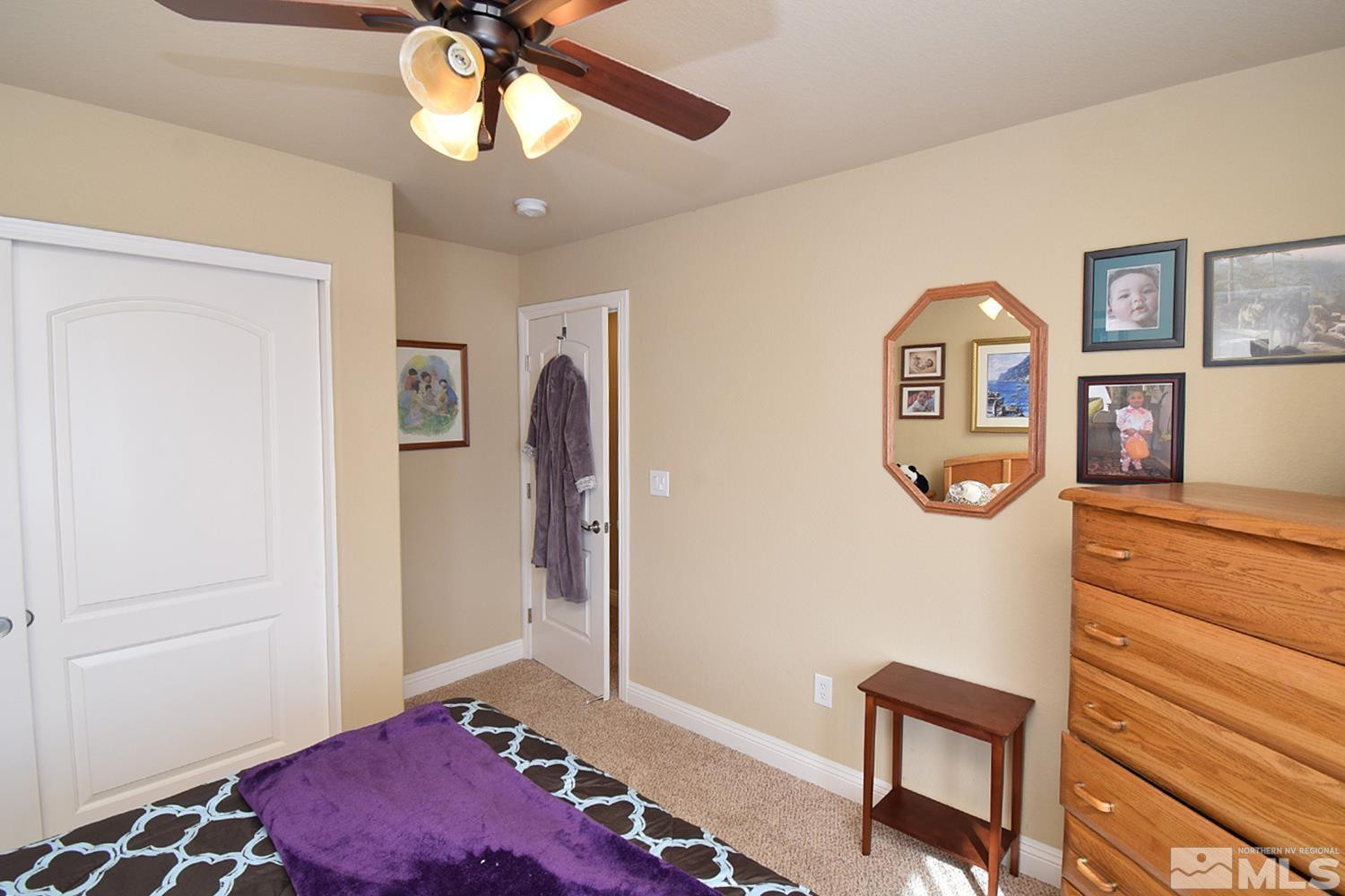 10685 Solano Court Reno, NV 89521 - Photo 26 of 32 a bedroom with a bed and a dresser in it