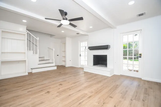 a view of an empty room with a fireplace and a window