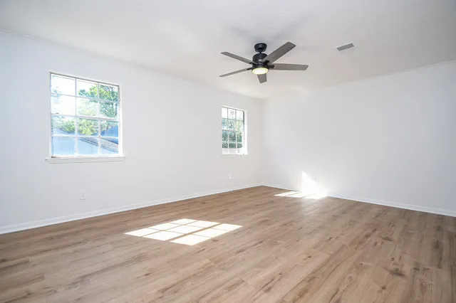 an empty room with cabinet and windows