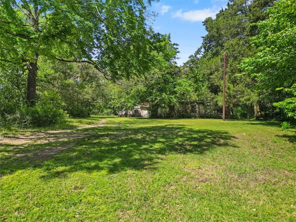 a view of a field with trees in the background