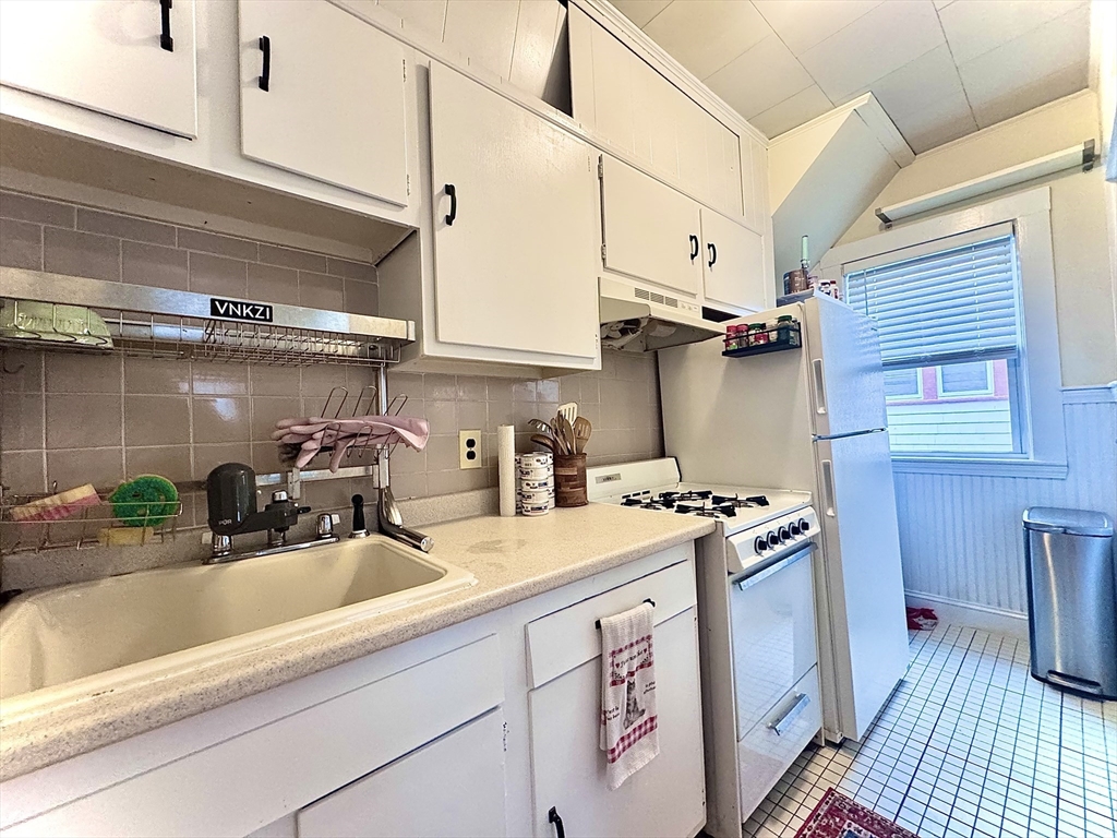 a kitchen with stainless steel appliances granite countertop a sink a stove and cabinets
