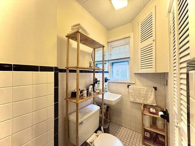 a bathroom with a toilet sink and mirror