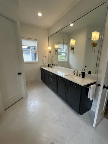 a bathroom with a double vanity sink toilet and shower