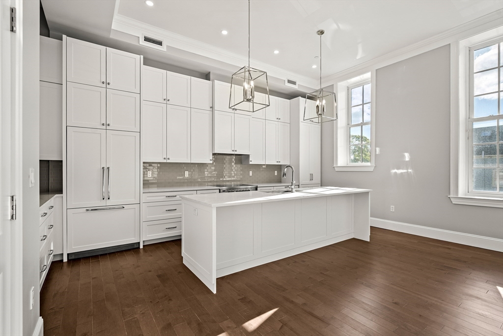 20 Mechanic Square, Unit 2 Marblehead, MA 01945 - Photo 13 of 42 a large white kitchen with granite countertop a stove a sink dishwasher and white cabinets with wooden floor