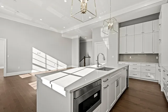 a kitchen that has a sink a stove and a wooden floor