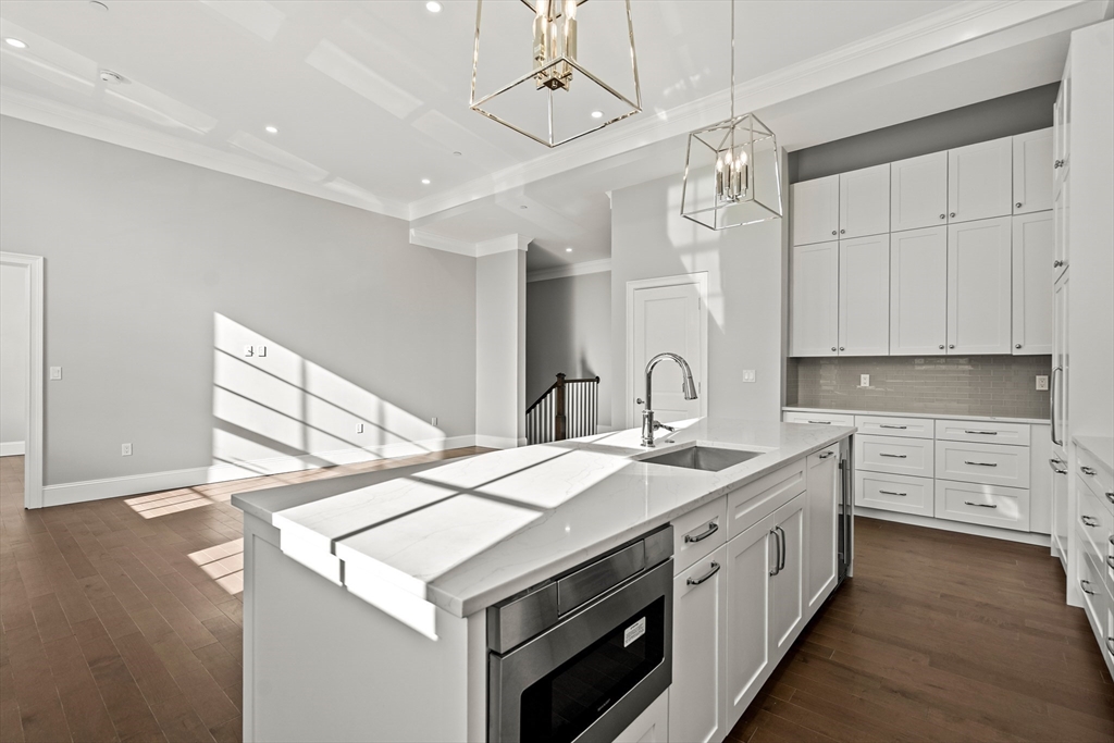20 Mechanic Square, Unit 2 Marblehead, MA 01945 - Photo 14 of 42 a kitchen that has a sink a stove and a wooden floor
