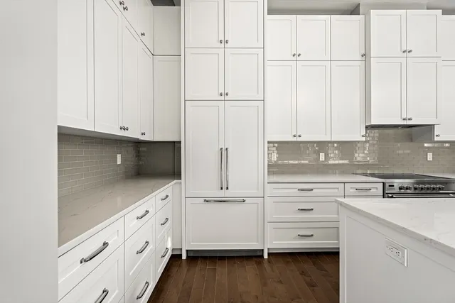 a kitchen with granite countertop white cabinets and white appliances