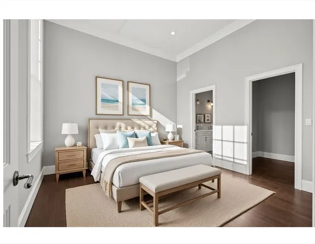 a bedroom with a bed a table and wooden floor