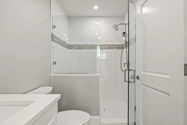 a bathroom with a shower a toilet and sink