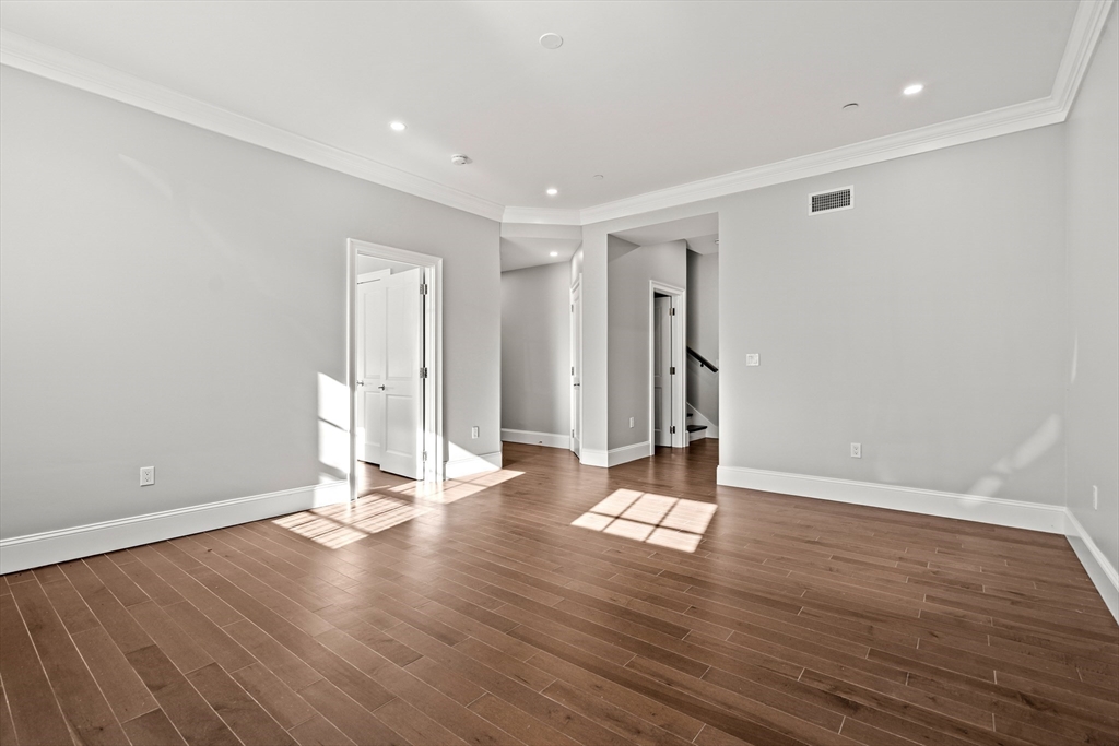 20 Mechanic Square, Unit 2 Marblehead, MA 01945 - Photo 35 of 42 a view of an empty room with wooden floor and a window