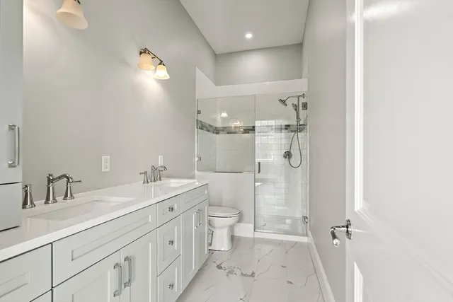 a bathroom with a double vanity sink toilet and shower