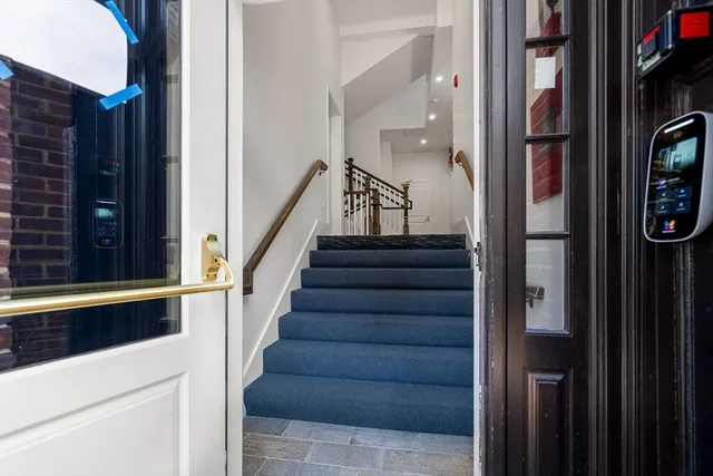 a view of staircase with lots of frames on wall and a window