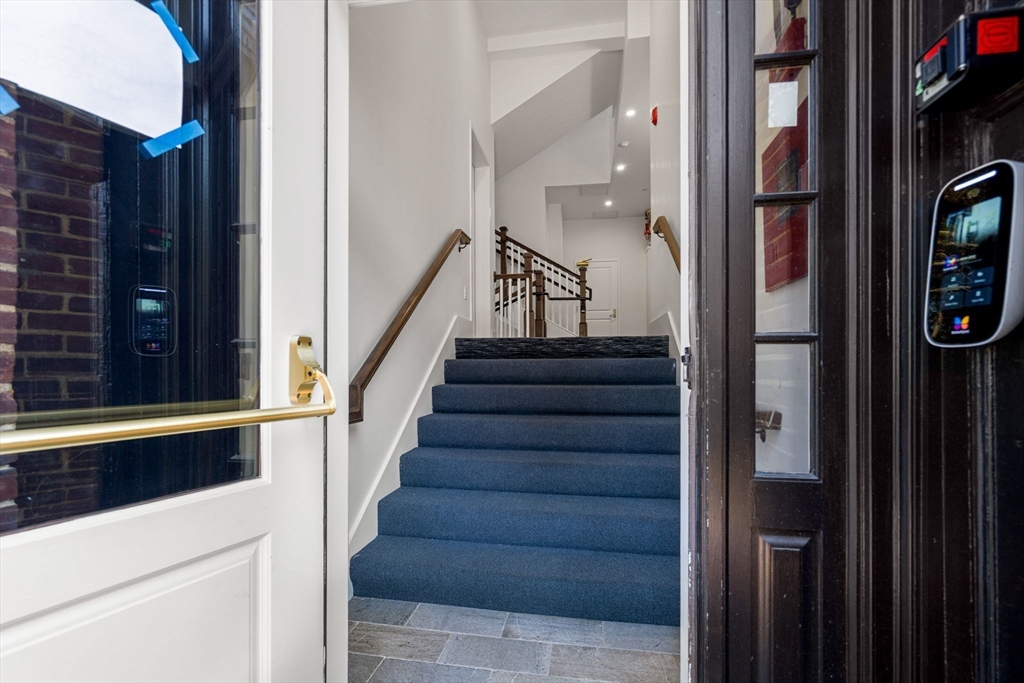 20 Mechanic Square, Unit 2 Marblehead, MA 01945 - Photo 5 of 42 a view of staircase with lots of frames on wall and a window