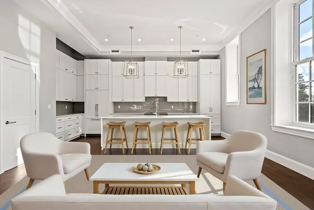 a living room with furniture a fireplace and a open kitchen view