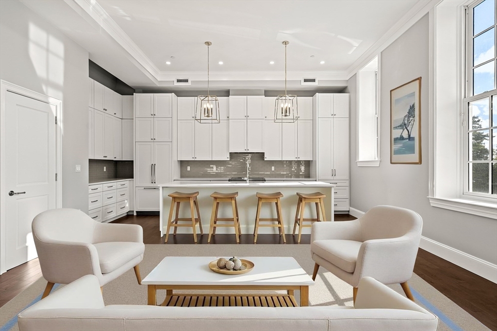 20 Mechanic Square, Unit 2 Marblehead, MA 01945 - Photo 8 of 42 a living room with furniture a fireplace and a open kitchen view