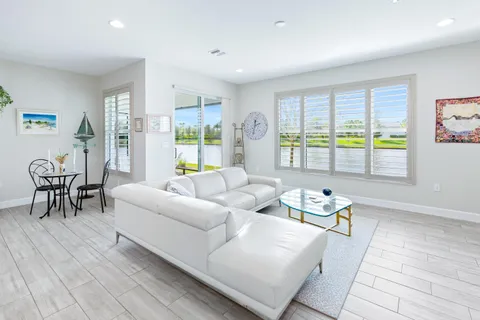 a large white kitchen with stainless steel appliances granite countertop a stove and a wooden floors