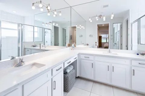 a spacious bathroom with a granite countertop sink a mirror and a bathtub