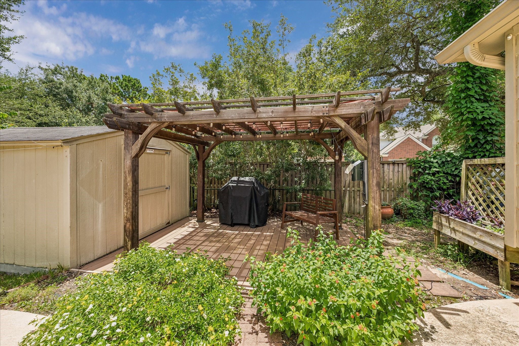 5811 Walkabout Way Katy, TX 77450 - Photo 28 of 33 Charming pergola-covered patio creates the perfect setting for outdoor dining, weekend barbecues, and relaxing evenings under the string lights.