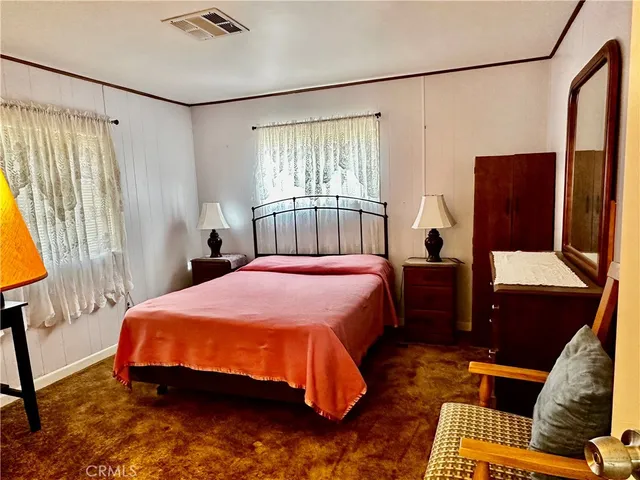 a bedroom with a bed window and a flat screen tv