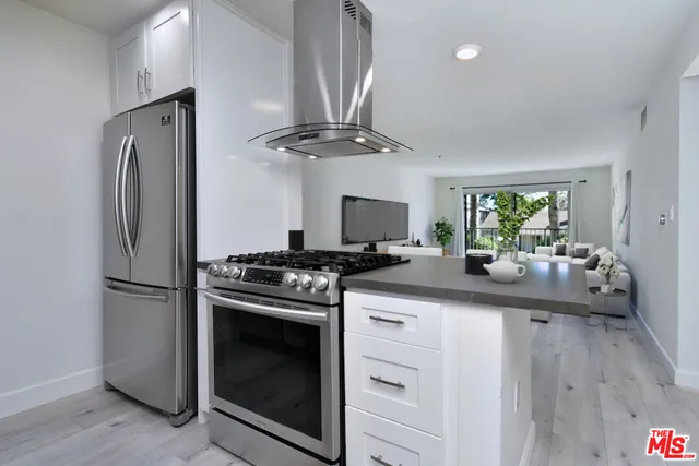 a kitchen with stainless steel appliances a stove a sink and a refrigerator