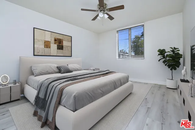 a bedroom with bed and a potted plant