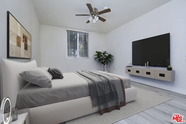 a bedroom with bed and a flat screen tv