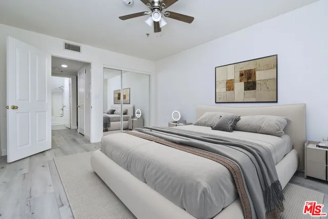 a spacious bedroom with a bed and ceiling fan