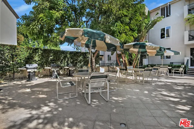 a view of a patio with a table and chairs and potted plants