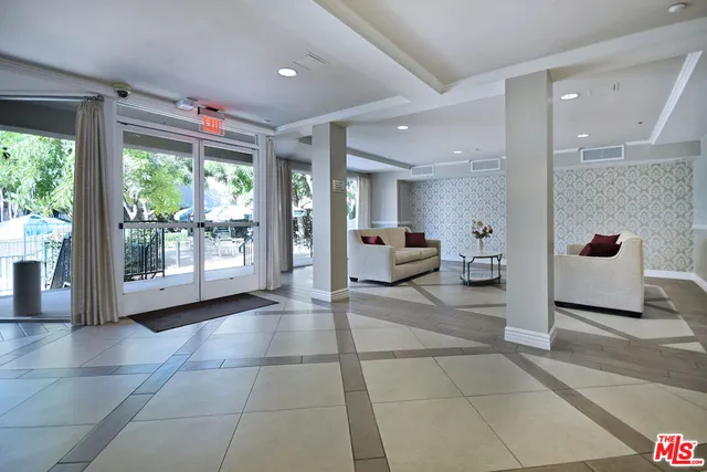 a view of a hallway with furniture and a large window