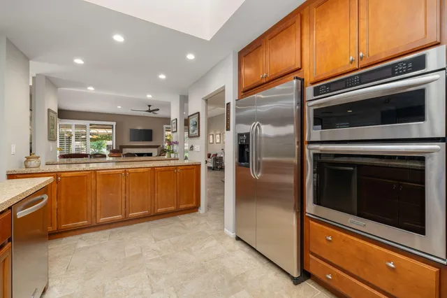 a kitchen with stainless steel appliances granite countertop a refrigerator and a sink