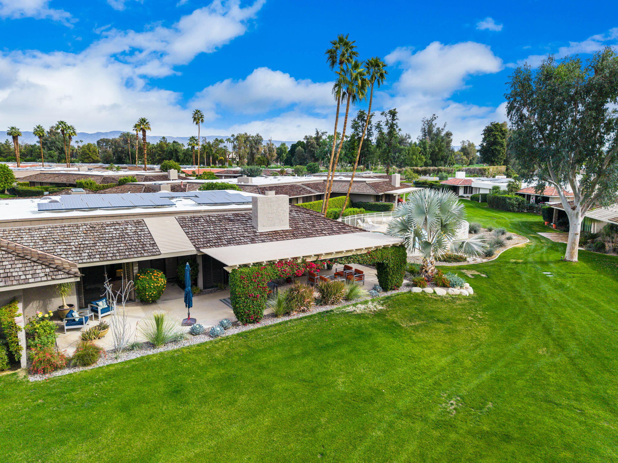 3 Tulane Court Rancho Mirage, CA 92270 - Photo 38 of 47 a view of a swimming pool with lawn chairs and a big yard