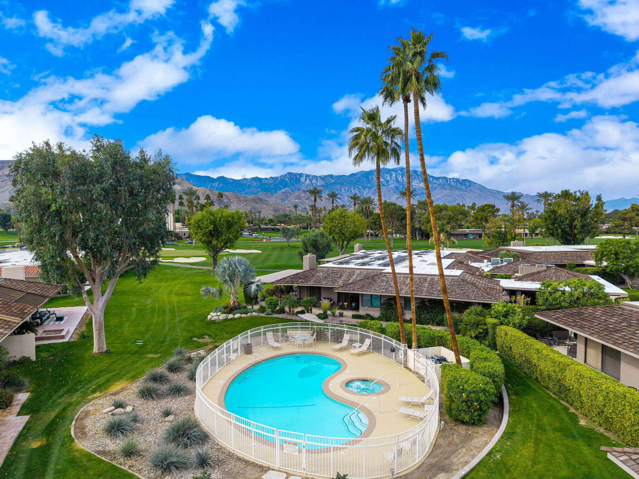 3 Tulane Court Rancho Mirage, CA 92270 - Photo 40 of 47 a view of a swimming pool with a table and chairs under an umbrella